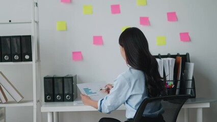 Wall Mural - Young successful employee business woman in blue shirt hold paper account documents work, analyzing the paper in office room.