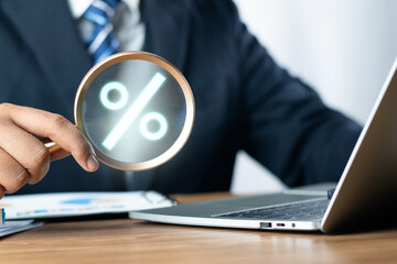 Concept of financial interest rates and dividends provision of financial services. Businessman using magnifying glass finding to interest rate. Interest Rates Stocks Finance Ratings Mortgage Rates.