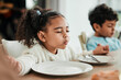 © Daniels C/peopleimages.com - Kids, holding hands and praying at dinner, home and faith for gratitude, solidarity and mindfulness for food. Children, prayer and religion for event, lunch or brunch with eyes closed in family house