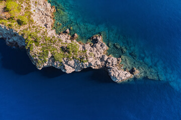 Poster - Rocky cliff aerial view. Azure sea or ocean coast. Summer resort and vacation destination