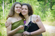 © Олеся Тамилович - Two girlfriends are standing in the forest in summer.