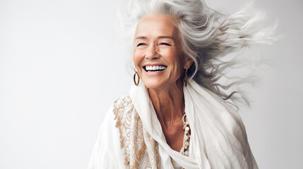 Portrait of a smiling woman in her 70s on a white background. Lifestyle.