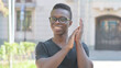© stockbakers - Outdoor Portrait of Excited Young African Man Clapping for Team