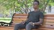 © stockbakers - Serious Young African Man Sitting Outdoor