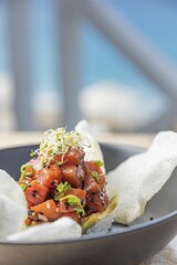 Sticker - Closeup of fresh tuna tartare in a black plate on the table