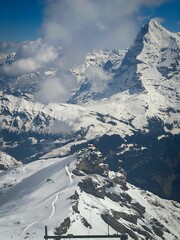 Sticker - High-angle view of a snow-capped mountain range with blue sky background