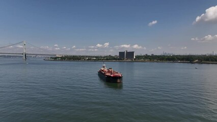 Poster - Aerial video of a boat in the deep blue sea with a shore in the background