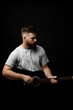 © Volodymyr - Portraite of handsome brunette bearded man musician, guitarist standing and holding a acoustic guitar in a hand.