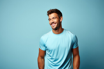 Wall Mural - Portrait of smiling young man of athletic build in sports uniform isolated on blue background. Creative banner of fitness center with copy space.