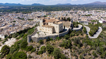 Wall Mural - Aerial view of the pilgrimage church of Sant Salvador surrounded by fortification walls on a hill overlooking the town of Artà on Majorca in the Balearic Islands, Spain