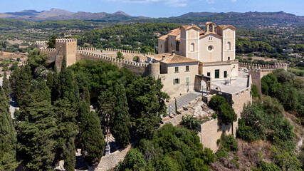 Wall Mural - Aerial view of the pilgrimage church of Sant Salvador surrounded by fortification walls on a hill overlooking the town of Artà on Majorca in the Balearic Islands, Spain