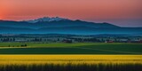 Fototapeta Natura - a huge landscape with mountains far and big crop farms in foreground at sunrise