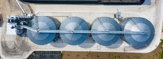 Aerial top view of modern agricultural Silo. Set of storage tanks cultivated agricultural crops processing plant.