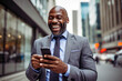 © vefimov - Professional and business-focused smiling businessman confidently holding smartphone while in the bustling city. Concept of success.
