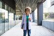 Portrait of Young African American business woman in trendy blazer and eyeglasses standing on corporate office