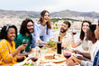 © Xavier Lorenzo - Group of multiracial friends enjoying summer barbecue dinner party at home terrace.