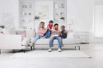 Wall Mural - Happy family having fun together on sofa at home