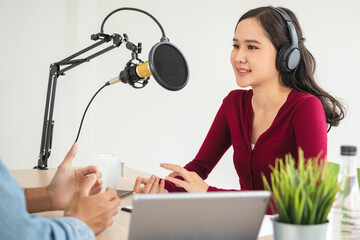 Smile two asian young woman, man radio hosts in headphones, microphone while talk, conversation, recording podcast in broadcasting at studio together. Technology of making record audio concept.