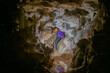 Young woman spelunking inside a cave. Feminism concept. Concept of women's sport.