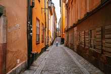 Man Walking Along The Narrow Cobblestone Streets Of Stockholm Gamla Stan (old Town)