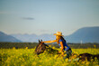 © Cavan Images - Girl laughing on horseback through a canola field in Montana