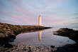 © Cavan Images - Lighthouse on shore near ocean at sundown