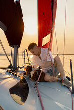 A Young Man On A Yacht With A Dog. Cavalier King Charles Spaniel