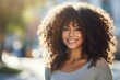 © photo of people - Young happy cute pretty beautiful African American ethnic woman with curly hair looking at camera in city street outdoors on sunny day. generative AI