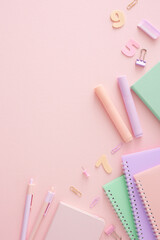 Engage with the educational journey. Top view vertical composition of notebooks, pens, markers, rubber, pins, clips, numbers on pastel pink background with empty space for promo or text