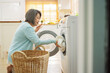 © Kiattisak - Asian Senior woman housekeeper loading clothes to washing machine. Routine activity in house concept.