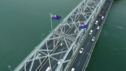 Wall Mural - Auckland, New Zealand: Aerial drone footage of the Auckland harbor bridge in the Hauraki gulf with heavy traffic in New Zealand largest city. Shot with a rotation motion