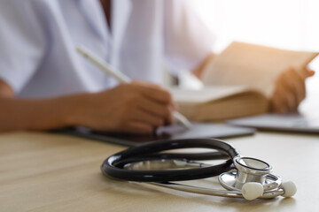 Wall Mural - Doctor using digital tablet and reading book