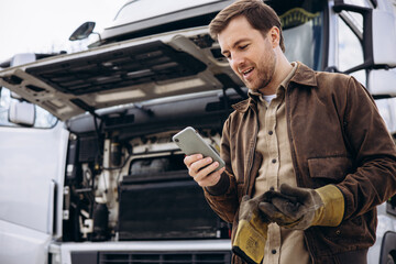 Canvas Print - Truck driver stopped on the road reparing his lorry