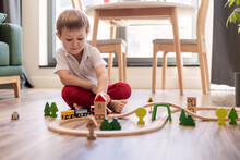 Child Boy Playing With Toys Indoors At Home In The Children's Room