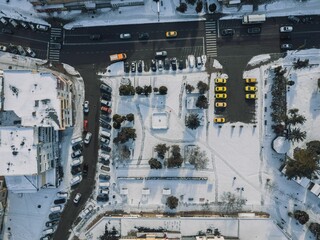 Canvas Print - Bird's eye view of the cars driving on the road on the snowy town