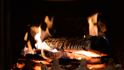 Poster - Closeup footage of burning wood in the fireplace against the black background