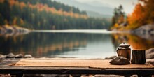 Wooden Table With Teapot In Front Of Blurred Background Of Autumn Forest And Lake. Lake, Mountains And Forest.