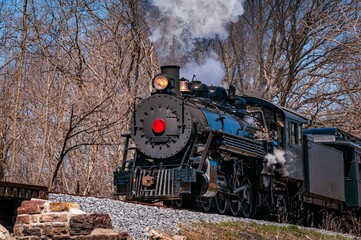 Sticker - A steam passenger train moving slowly blowing lots of black smoke and white steam on a sunny day.