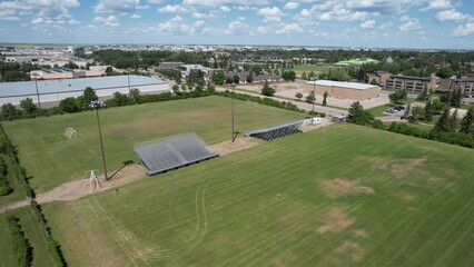 Wall Mural - Aerial footage of suburban houses with green lawns trees  and solar panels under blue sky