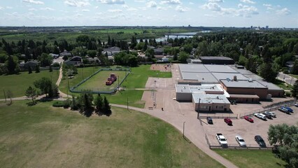 Sticker - Aerial footage of suburb houses zone with trees and river in the background under blue cloudy sky