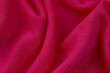 Closeup image of a soft, pink fabric texture with subtle details of the weave visible