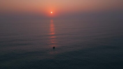 Poster - Aerial video of a boat in the sea during scenic orange sunset in the evening