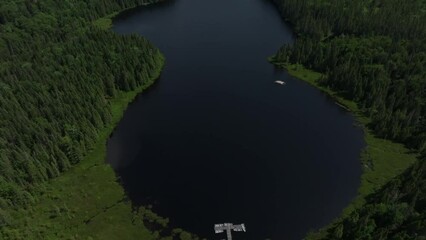 Sticker - Aerial of a calm lake surrounded by dense calm forest during the early morning