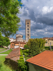 Wall Mural - Lucca charming historical center. San Frediano (St Fredianus) medieval church apse with bell tower seen from city ancient walls