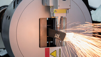 Poster - Close up scene the fiber laser cutting machine cutting  machine cut the stainless steel tube. The hi-technology sheet metal manufacturing process by laser cutting machine. technical concept background