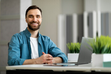 Aufkleber - Portrait of freelancer man sitting at desk with laptop computer at office
