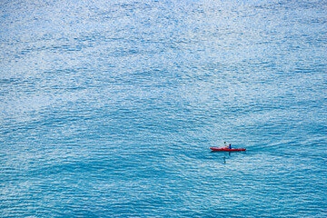 Person kayaking on blue sea.