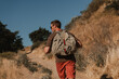 © gstockstudio - Rear view of male adventurer with backpack walking by the mountain footpath