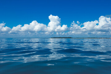 Wall Mural - clouds on blue sky over calm sea with sunlight reflection