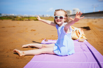 Wall Mural - Adorable preshooler girl playing on the sand beach at Atlantic coast of Brittany, France